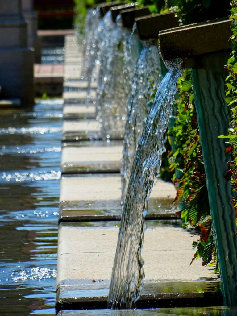 Aesthetic garden fountain with multiple streams of cascading water creating a serene atmosphere.
